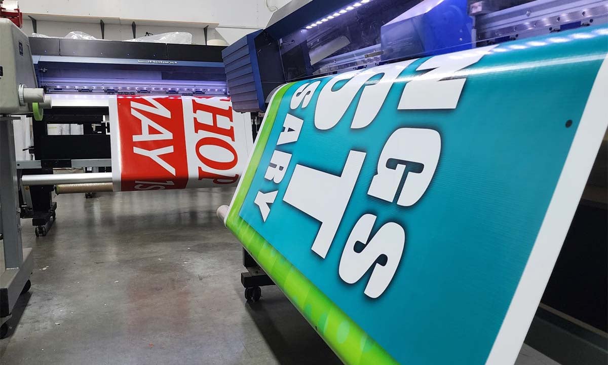 Full-color outdoor vinyl banner with grommets, custom printed by Sign Pro for a grand opening event at a retail storefront